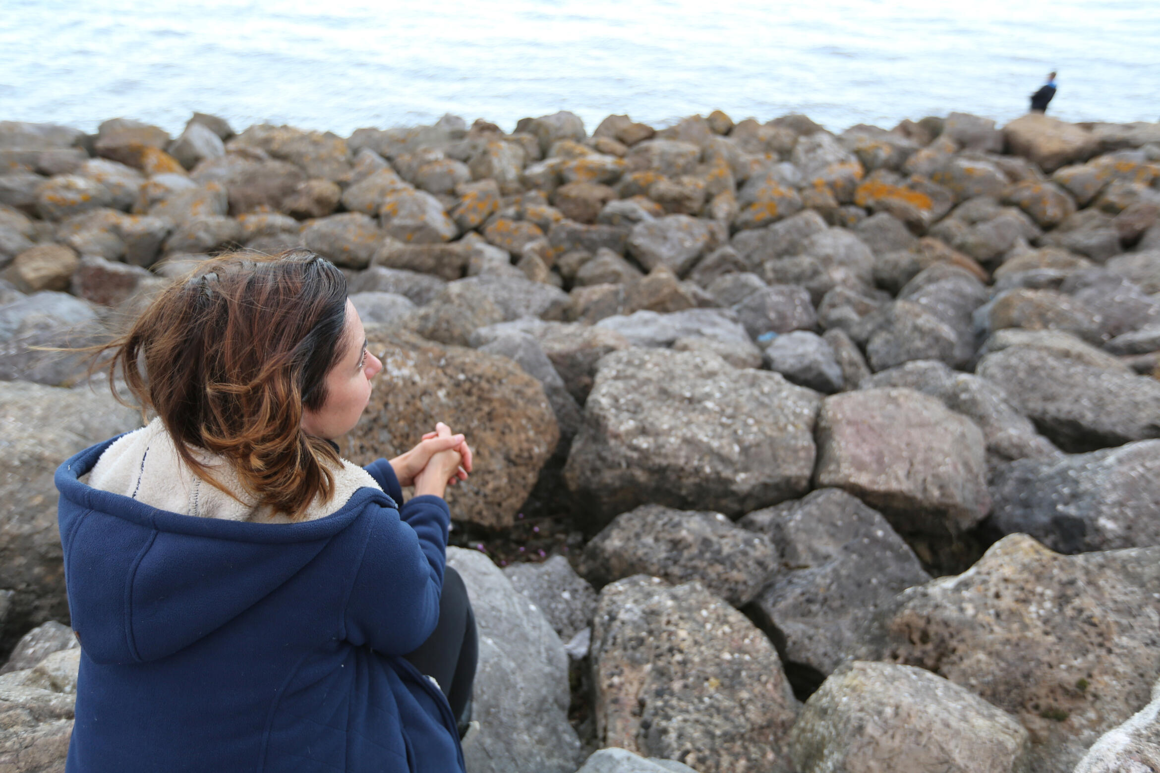 Head and shoulders of a counsellor with short hair hair and blue scarf.
